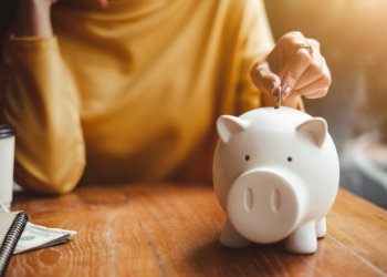 woman putting money into piggy bank