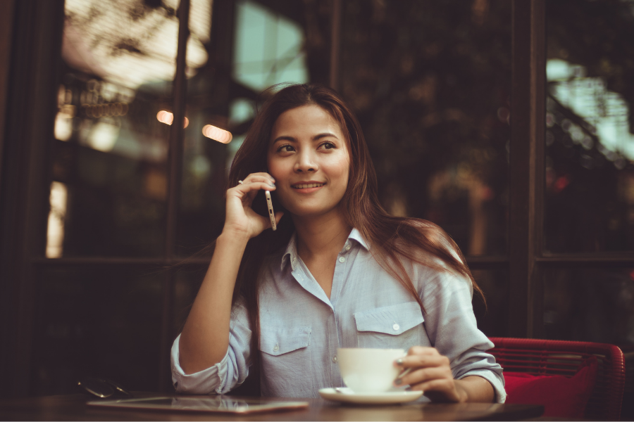 woman on phone drinking coffee