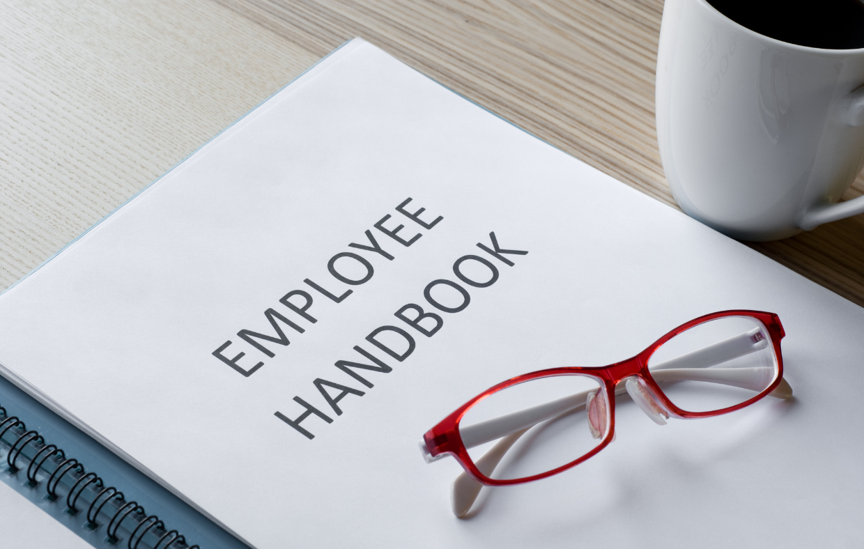 employee handbook with red glasses sitting on top