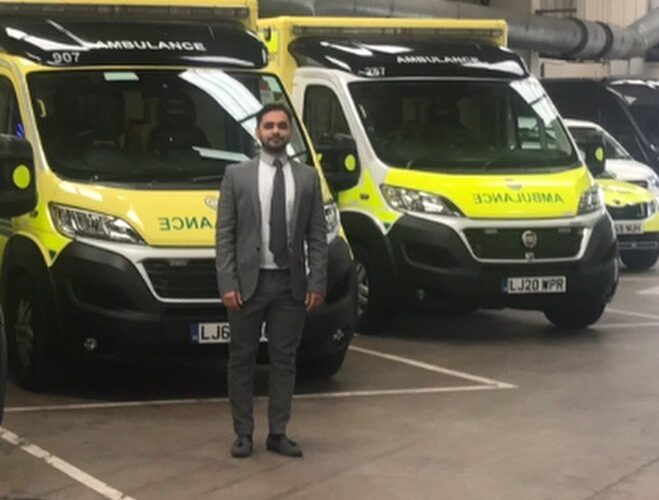 Bilal standing in front of ambulances